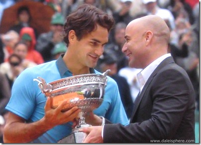 2009 french open - andre agassi hands roger federer the cup